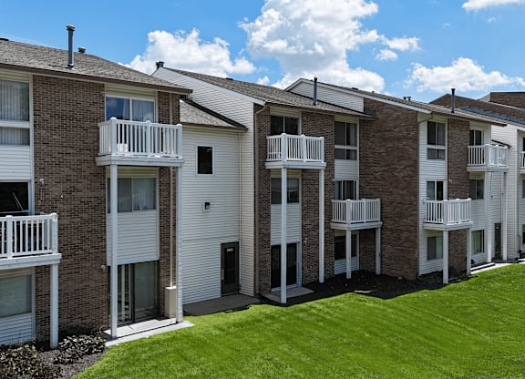 A row of apartment buildings with balconies and doors.