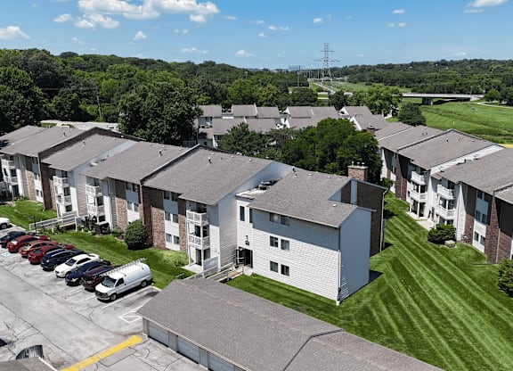 Apartment complex with a parking lot in front.
