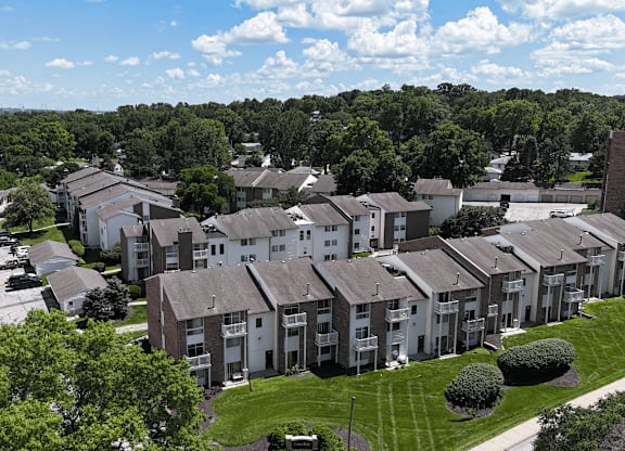 Apartment complex with a parking lot in front.