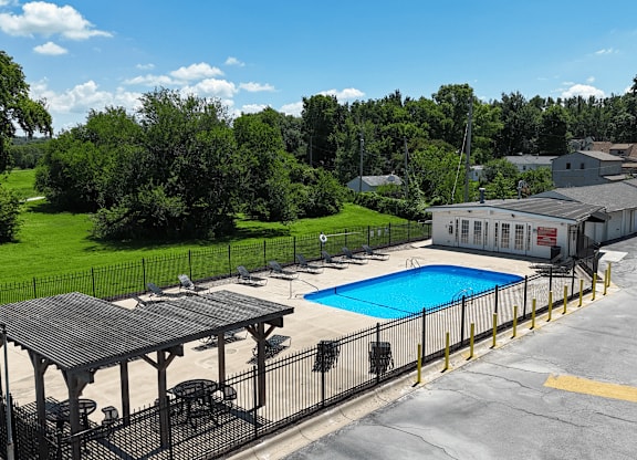 A pool area with a pavilion and a building in the background.