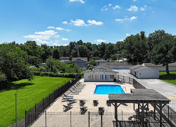 A pool surrounded by a fence and a pavilion.