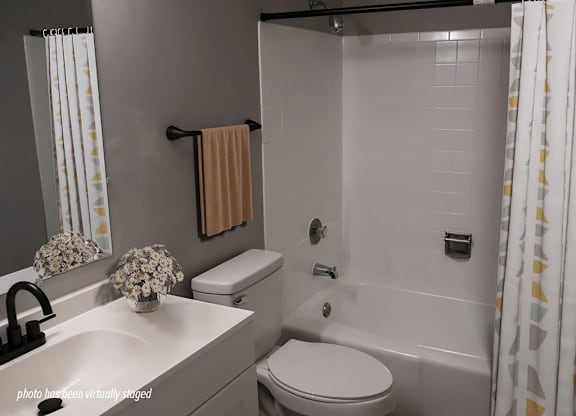 A bathroom with a white sink, toilet, and shower.