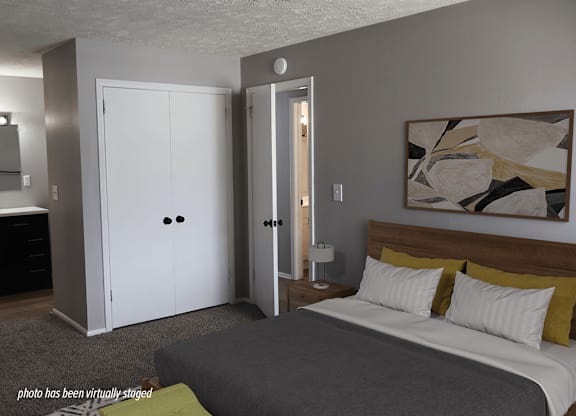 A bedroom with a bed, nightstand, and two doors.