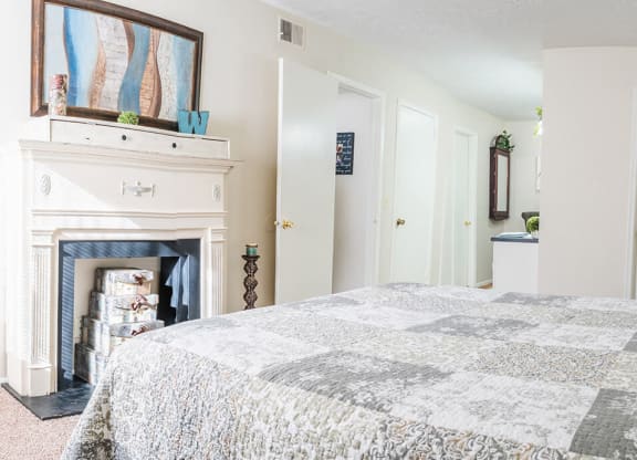 a bedroom with a large bed and a fireplace