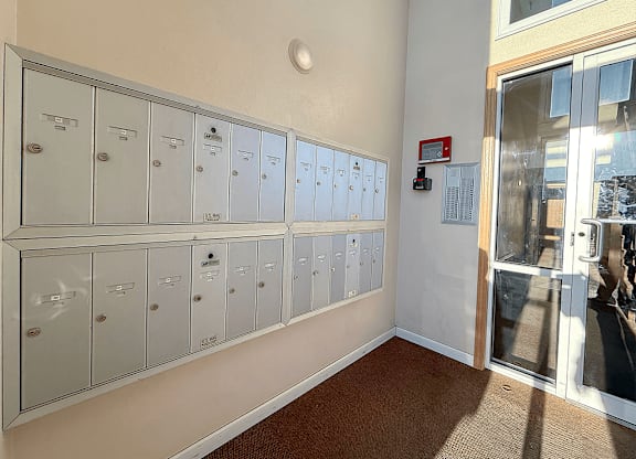 A row of white lockers are lined up against a wall.