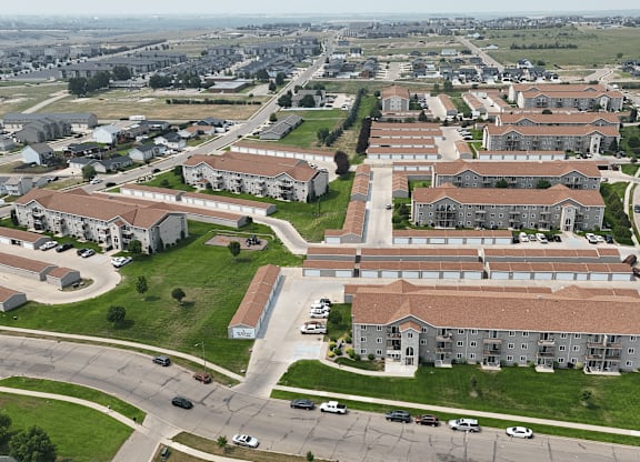 A large apartment complex with a parking lot in front.
