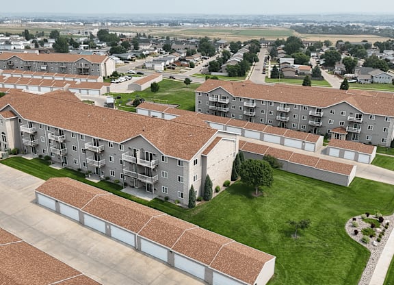 Apartment complex with a parking lot in front.
