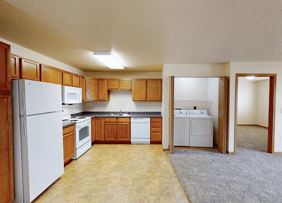 A kitchen with white appliances and wooden cabinets.