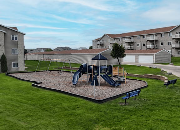 A playground with a slide and a swing set.