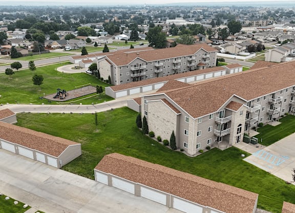 Apartment complex with a large grassy area in the foreground.