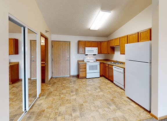A kitchen with a white refrigerator, white microwave, and white oven.