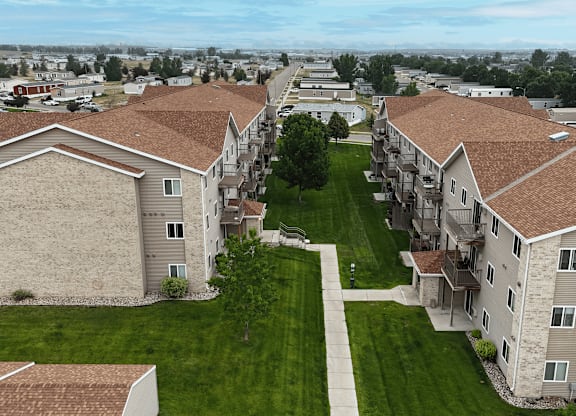 Apartment complex with brown roofs and green lawns.