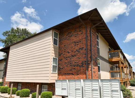 the front of a house with a brick wall and a staircase
