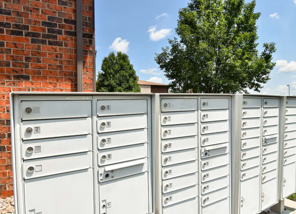a bunch of mailboxes sitting on top of a fence