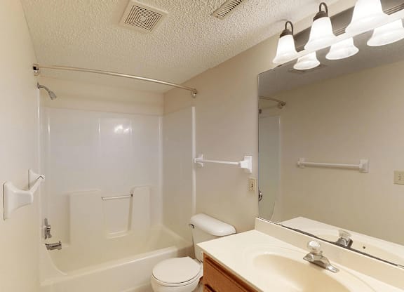 A white bathroom with a toilet, sink, and bathtub.