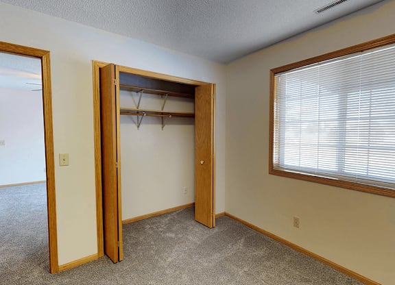 A room with a closet and a window.