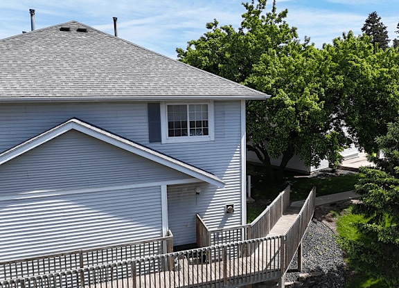 A house with a grey roof and a white fence.