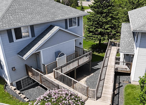 A house with a grey roof and a deck with a railing.