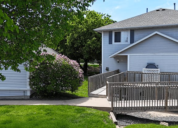 A house with a grey roof and a white fence.