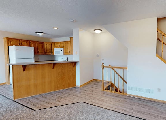 A kitchen with wooden cabinets and a white refrigerator.
