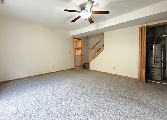 A room with a ceiling fan and a carpeted floor.