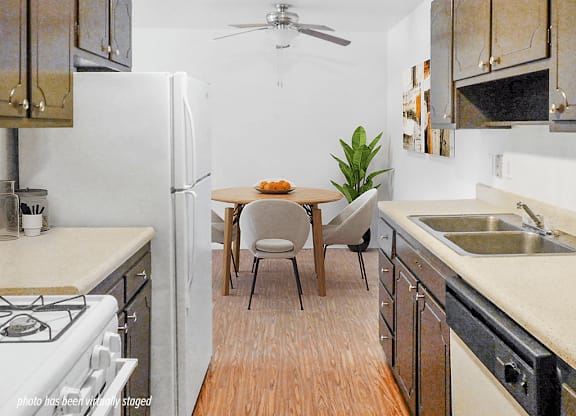 A kitchen with a table and chairs in the middle.