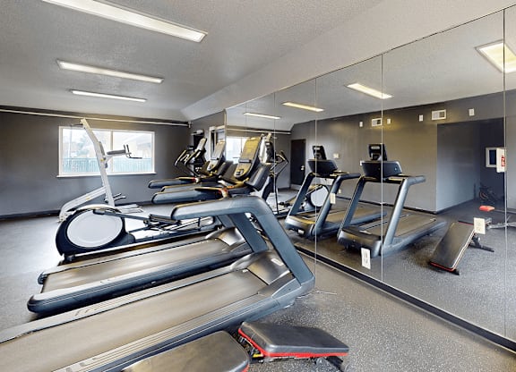A gym with treadmills, elliptical machines, and other exercise equipment.