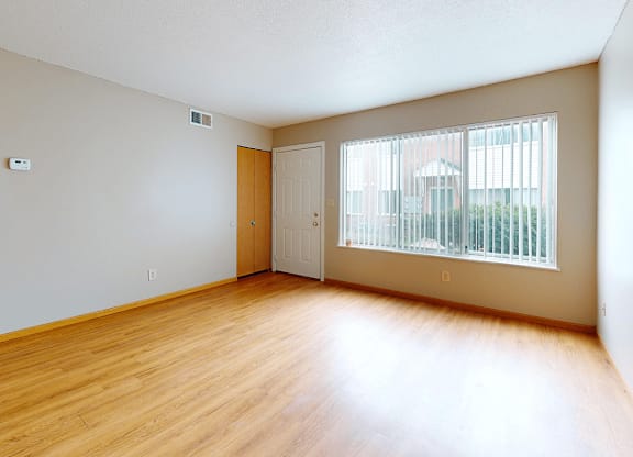 Empty room with wooden floor and white walls.