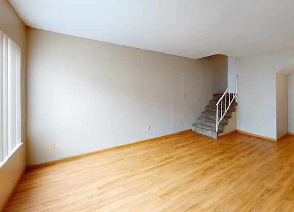 A room with wooden floors and a staircase.