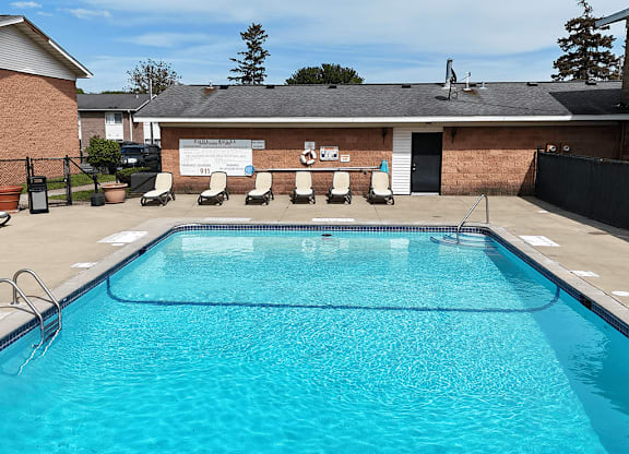 A swimming pool in front of a building with a white signboard.