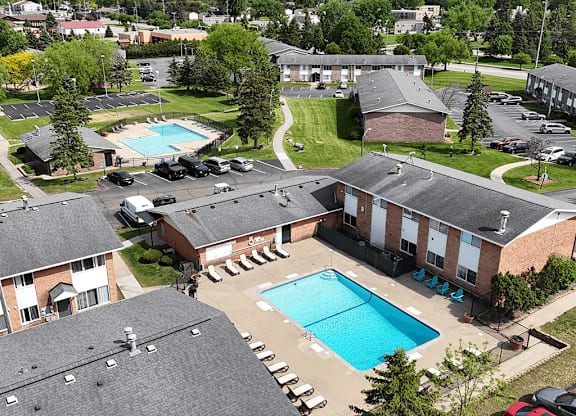 A large swimming pool is surrounded by apartment buildings.