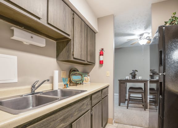 a kitchen with a sink and a refrigerator and a table with a chair