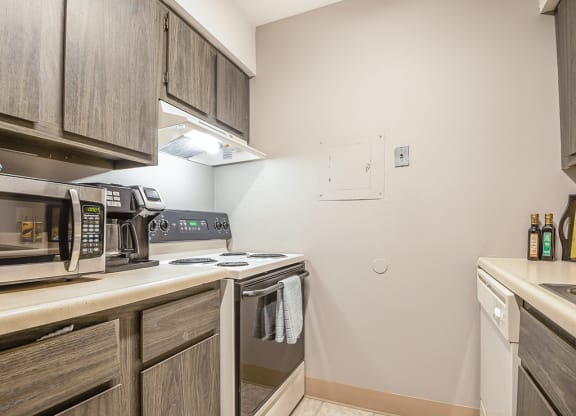 a kitchen with a stove and microwave and wooden cabinets