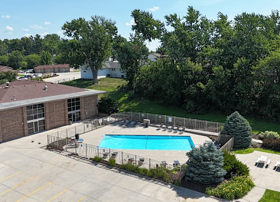 A pool surrounded by a fence and trees.