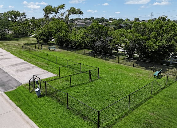 A black fence encloses a green lawn.