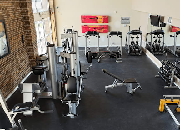 A gym with a variety of equipment including weights and weight machines.