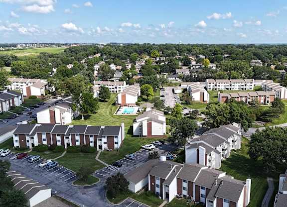 A bird's eye view of a residential area with houses and a swimming pool.