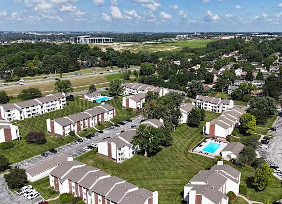 A large apartment complex with a swimming pool in the middle.