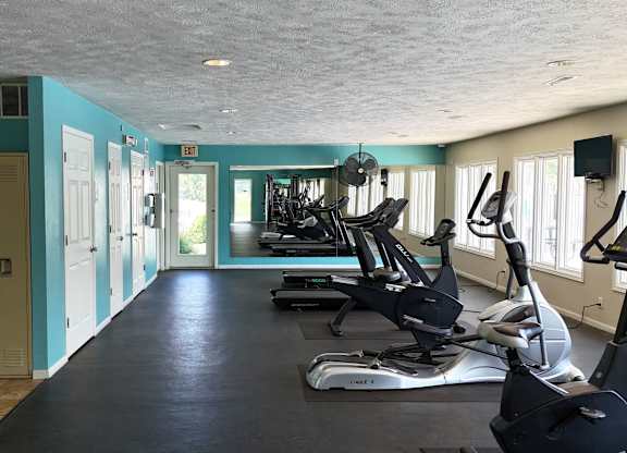 A gym with exercise equipment and a blue wall.