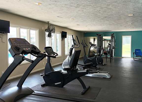 A gym with treadmills and elliptical machines.