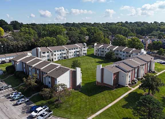 A large apartment complex with a parking lot in front.
