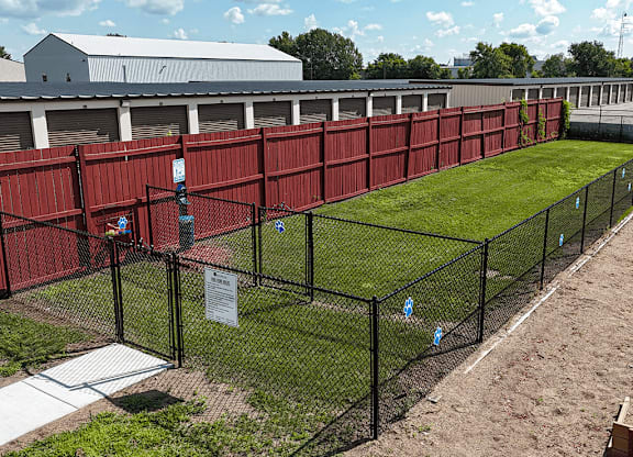A chain link fence surrounds a green field.