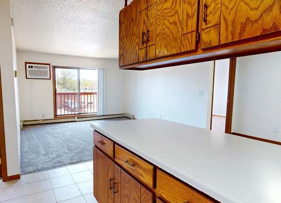 A kitchen with wooden cabinets and a white counter top.