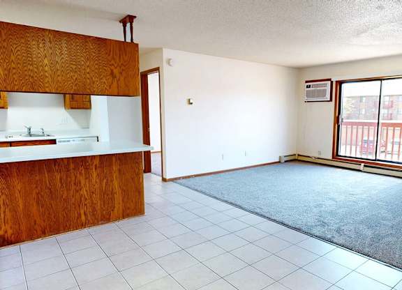 A kitchen with white tiles and a wooden counter.