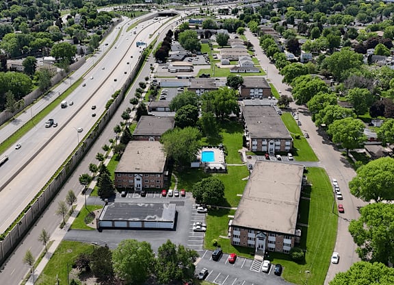 A highway runs parallel to a residential area with houses and apartment buildings.