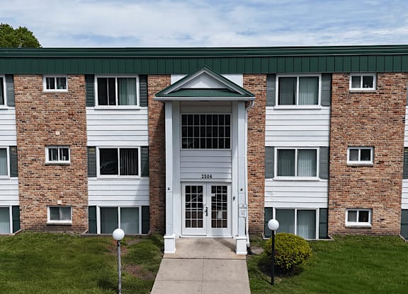 A brick building with a white door and windows.