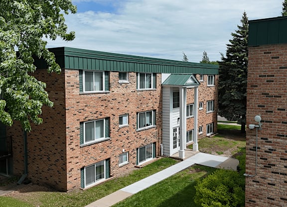 A red brick building with a green roof and white trim.