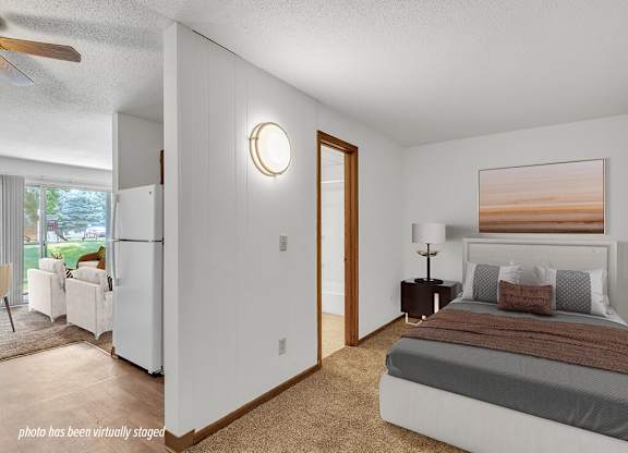 A bedroom with a bed, nightstand, and a painting on the wall.