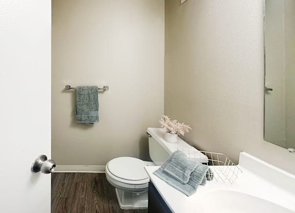A white toilet sits next to a white sink in a bathroom.
