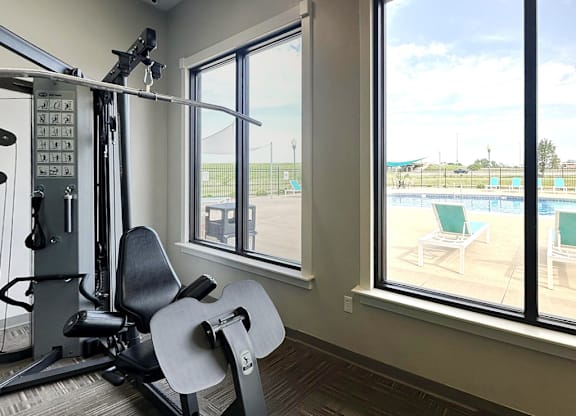 A gym with a view of a pool and a track.